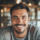 Homme souriant dans un café chaleureux.